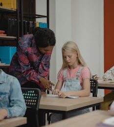 A teacher assisting a student in a classroom, fostering learning and engagement.
